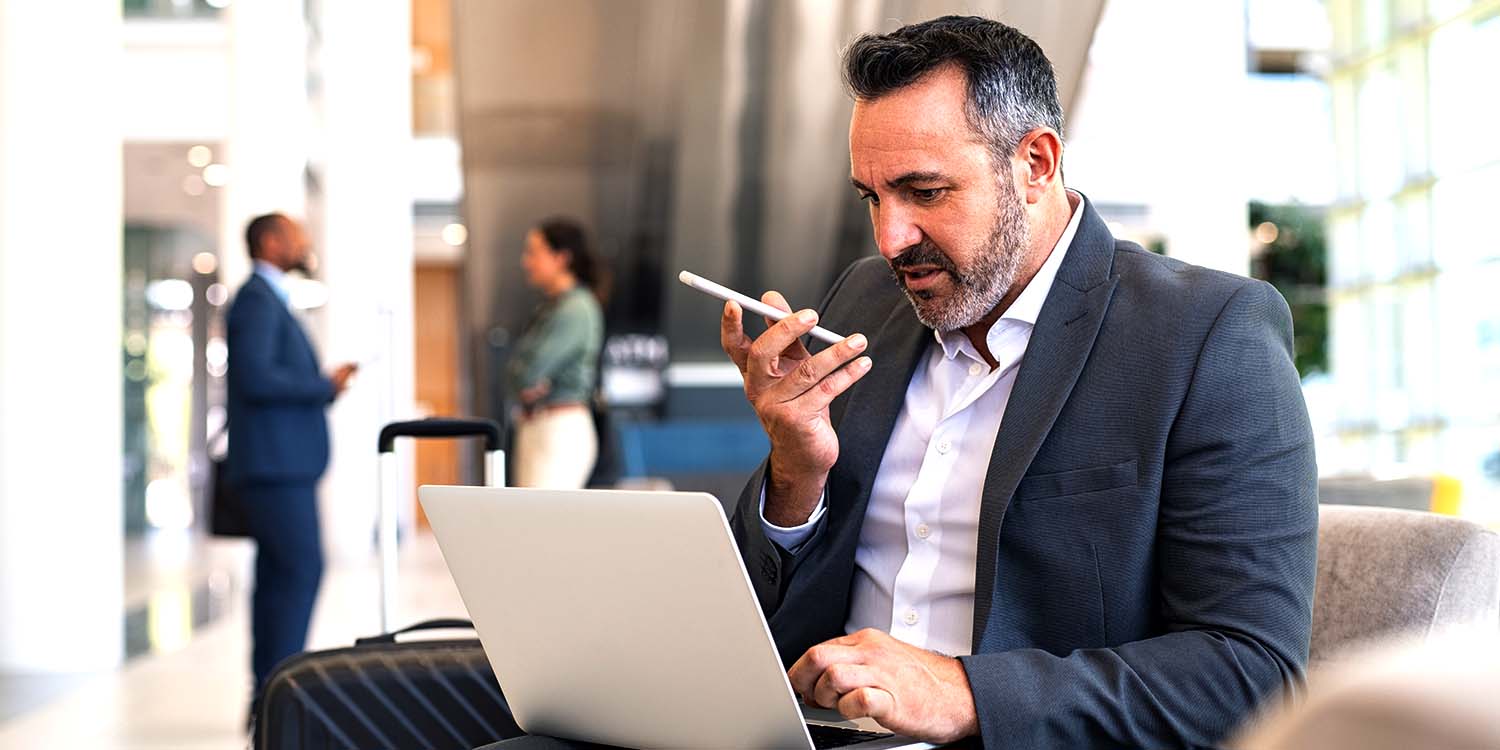 Man using mobile and laptop on airport